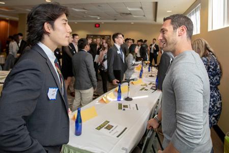 College student and an employer meet at a career fair 